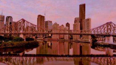 Köprünün Brisbane Nehri ve Brisbane şehrinin arka planında yer alan su yansımasına vurgu yaparak Story Köprüsü 'nün solundan sağa kaydır. Queensland turizm konsepti 6k video 18 saniye