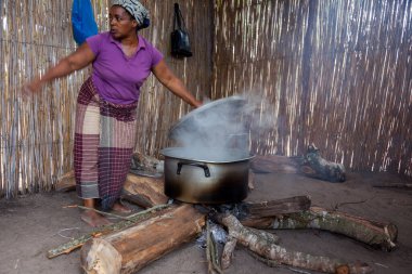 Xai Xai Mozambik: Kadınlar kaba bir mutfakta, hayır işçileri ve çocuklar için bir tarlada sopa duvarları olan yemekleri otantik ve geleneksel yollarla hazırlıyorlar.