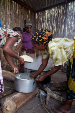 Xai Xai Mozambik: Kadınlar kaba bir mutfakta, hayır işçileri ve çocuklar için bir tarlada sopa duvarları olan yemekleri otantik ve geleneksel yollarla hazırlıyorlar.