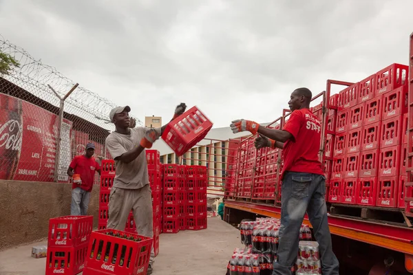 Maputo Mozambik, 22 Nisan 2011: Maputo 'da Coca Cola sandıklarıyla dolu bir kamyonu yükleyen iki işçi
