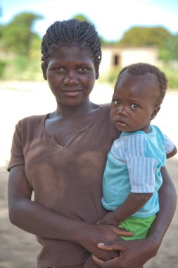 Xai Xai, Mozambik: Xai Xai 'nin dışındaki bir köyde, kimliği belirsiz Afrikalı bir genç anne ve oğlunun ortak bir kulübenin önünde görüntüsünü kapatın