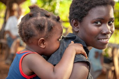 Xai Xai, Mozambik: Kimliği belirsiz genç Afrikalı kız ve küçük kız kardeşinin kameraya gülümseyen bir sırtına yakın çekim.