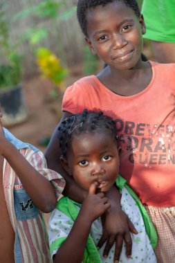 Xai Xai, Mozambik: Kamera ve müteakip görüntüleriyle ilgilenen kimliği belirsiz iki Afrikalı kızın ön görüntüsü. Bir huzursuzluk hissi gösteren bir portre biçimi