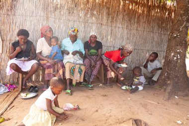 Xai Xai, Mozambik, Nisan 2014: Anneler ve yaşlı kadınlar, Xai Xai Mozambik 'in dışındaki fakir bir köyde çocuklara buharda pişmiş pirinç ve sebze yediriyor.