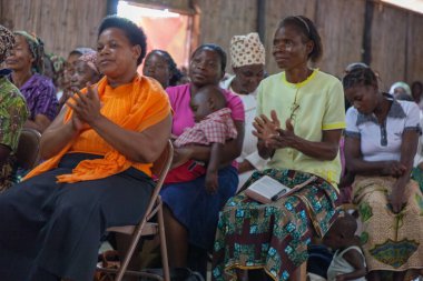 Pentecostal Christian Sunday kilisesindeki kimliği belirlenemeyen Afrika cemaatinin Pazar ibadetleri sırasında papazın gözlerini açık ya da kapalı olarak dinlemesini yakından izleyin. Ailelerin kefaret ve kurtuluş metaforuyla Pentekostal ibadet