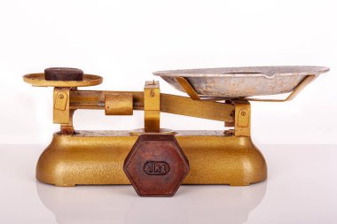 Beyaz zemin üzerinde demir ve antika tartılardan yapılmış 1 kilogram paslı standart metrik ağırlıkları kapatın. Kesme yolu. Ölçüm kavramı. Eski şeyler. Beyaz arka planda izole edilmiş eski metrik ağırlıklar. Altın rengi boya. Markette kullanılır.