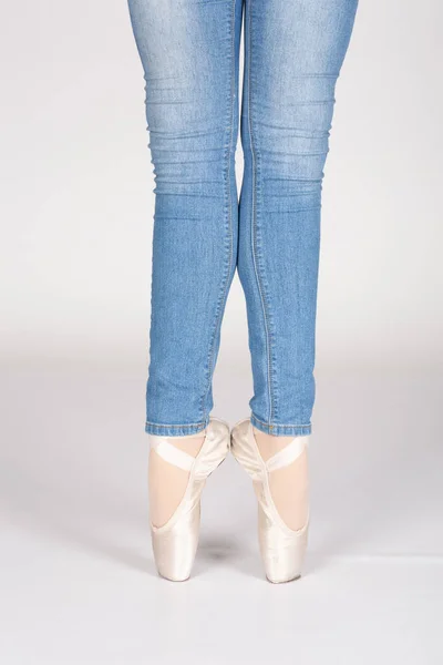En Pointe CORRECT heels together calves touching with blue jeans teachers perspective Young female ballet dancer showing various classic ballet feet positions for classical ballet or dance against a white background in blue jeans pink silk and satin