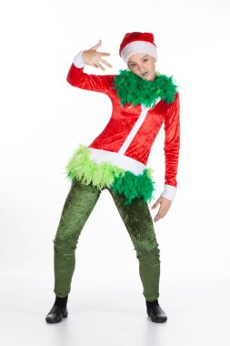 Kırmızı Noel Baba şapkası takan uzun boylu genç bir kız, Noel grinch pozu veren, beyaz arka planda soyutlanmış bir kız. Havalı adam, insani duygu yüz ifadesi.