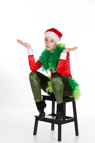Kırmızı noel baba şapkası takan genç bir kız. Beyaz arka planda soyutlanmış, ifadesinin havaya atıldığı bir grinch gibi. İnsan duygularını sorgulamak