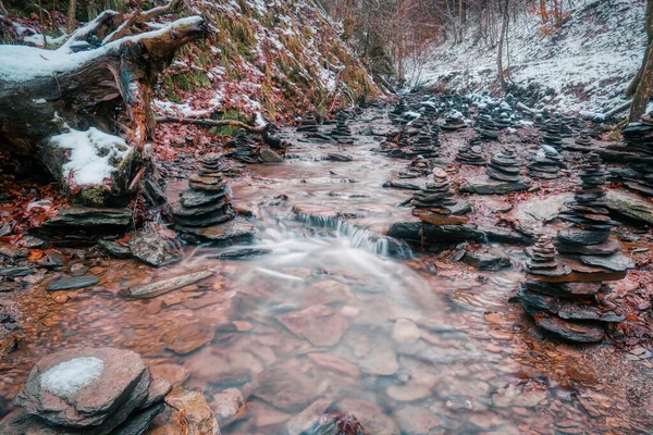 A creek with stone piles and gorge in the Helletal valley in Winterberg in snow