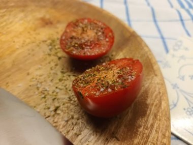Two tomato halves with herbs on a plate