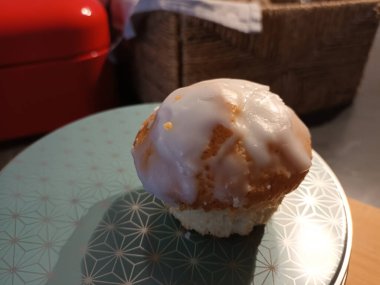 A lemon muffin on a cookie tin