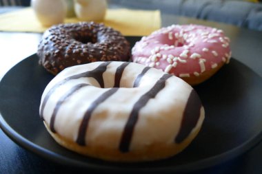 Oturma odasında bir tabakta üç çörek.