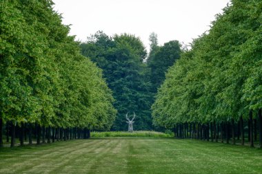 Sogel yakınlarındaki Clemenswerth şatosunda geyik heykeli olan tarihi kale parkı.