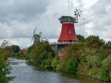 Two old windmills by the water in Greetsiel clipart