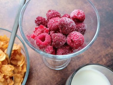 Süt, ahududu ve mısır gevreği.