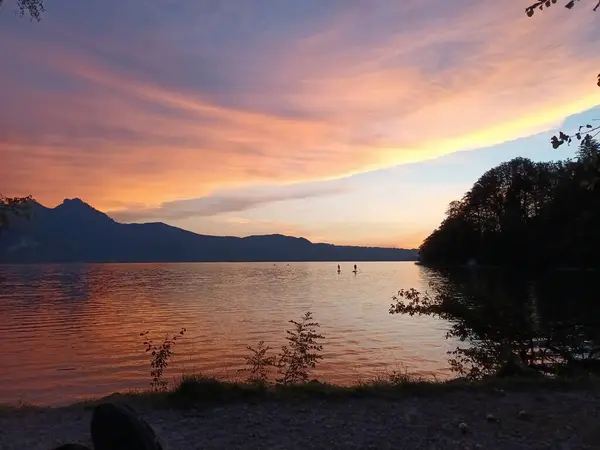 stock image Sunset and standup paddlers at lake Kochelsee and Alps