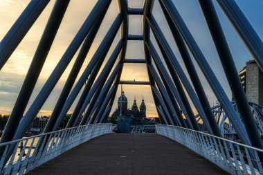 Gün batımında Amsterdam 'ın göbeğindeki köprü ve kilise