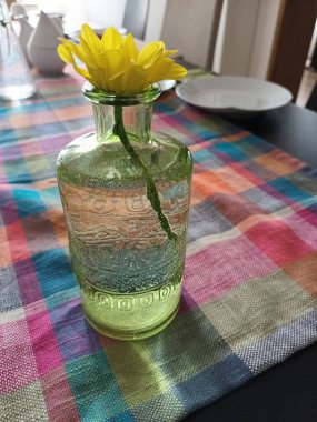 Vazodaki bir çiçek Masadaki yemek takımlarıyla