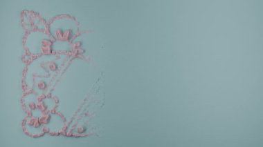 Döngü 3 boyutlu animasyon. Üzerinde bir süs bulunan mavi bir arkaplan, çiçeklerin içinde bir Paskalya tavşanı ve yumurta çizimi. Paskalya 3d canlandırması.