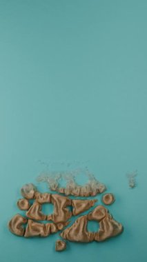 Yeni yıl için dikey 3D animasyon. Mavi yüzeyde altın bir kumaş şişer ve bir şablon oluşturur - 2025 yılının tarihi ve bir Noel ağacı. Yeni yıl için 3B döngü canlandırması