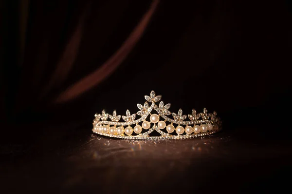 Luxury vintage crown on dark red satin, silk background