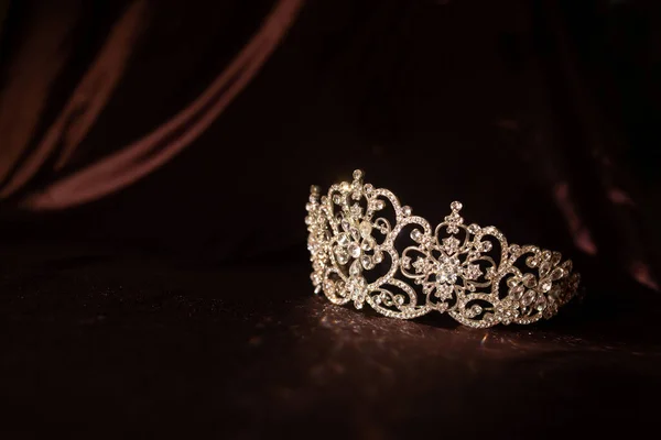 Luxury vintage crown on dark red satin, silk background