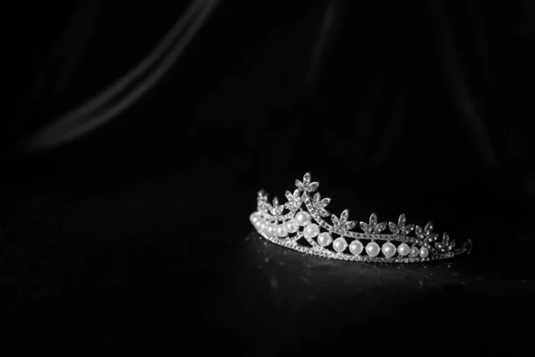 Luxury vintage crown on dark red satin, silk background. Black and white