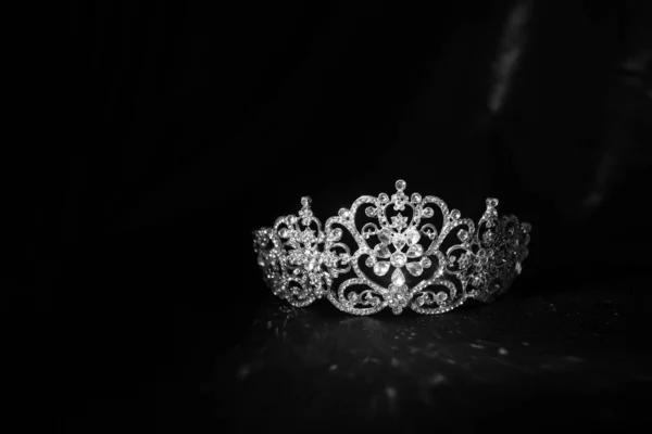 Luxury vintage crown on dark red satin, silk background. Black and white