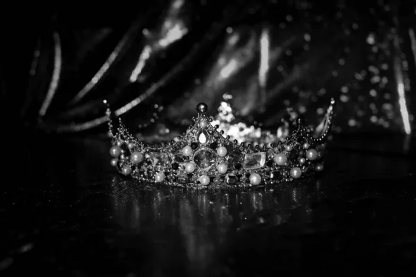 Vintage royal crown with precious gemstone on sparkle background. Black and white.
