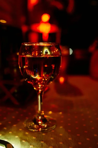Glass of wine in red light. Party