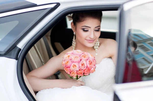 Portrait of happy positive bride. Sits in the car. Make up