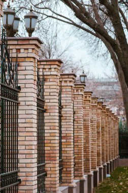 Günbatımında modern stilin kapısı ve kapısı olan Brick ve Metal Çit. Metal Çit Fikirleri. depo fotoğrafı