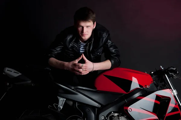 Handsome man model on motor bike in studio