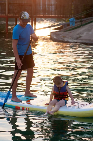 Dad and stand-up paddle board together. SUP board