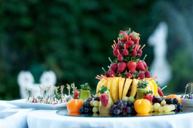 Atıştırmalık ve aperatiflerle servis masası. Açık büfede taze meyveli tatlı.