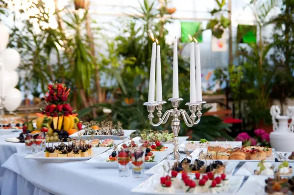 Atıştırmalık ve aperatiflerle servis masası. Açık büfede taze meyveli tatlı. İpuçları