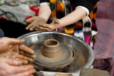 A boy creates a pot in a pottery workshop clipart