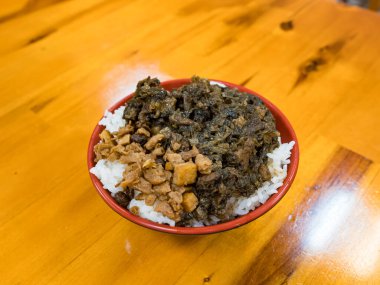 Kızarmış domuz eti ve sebze turşulu hakka pilavı.