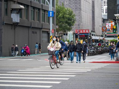 TAIPEI,TAIWAN - JAN 11 :People wearing face mask in street on January 11,2023 in Taipei,Taiwan.Because covid-19 pandemic caused countless deaths all over the world.