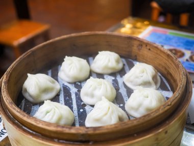 Steamed baozi dumplings stuffed with meat in a bamboo steamer.