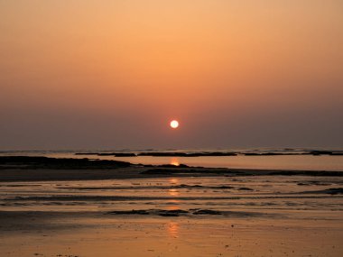 Sahilde gün batımı Altın arka planda
