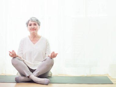 Üst düzey Asyalı kadın, evde spor yapıyor. Sağlıklı yaşam tarzı kavramı..