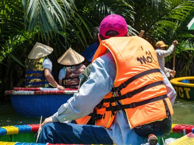 HOI AN, VIETNAM - 25 Mayıs 2024: Turistler bambudan yapılmış yuvarlak sepetin keyfini çıkarın Cam thanh köyünde yaşayan eşsiz bir Vietnamlı..