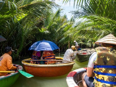 HOI AN, VIETNAM - 25 Mayıs 2024: Turistler bambudan yapılmış yuvarlak sepetin keyfini çıkarın Cam thanh köyünde yaşayan eşsiz bir Vietnamlı..