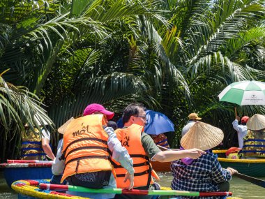 HOI AN, VIETNAM - 25 Mayıs 2024: Turistler bambudan yapılmış yuvarlak sepetin keyfini çıkarın Cam thanh köyünde yaşayan eşsiz bir Vietnamlı..