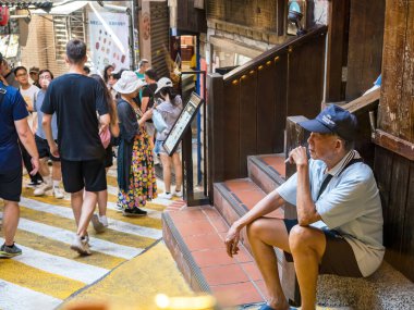 YENİ TAIPEI TAIWAN - 27 Ağustos 2024: Gezen ve alışveriş yapan turistlerle Jiufen eski caddesi. Geleneksel Çin fenerleri dar sokaklar boyunca asılı. Taipei yakınlarında popüler bir seyahat merkezidir..