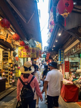 YENİ TAIPEI TAIWAN - 27 Ağustos 2024: Gezen ve alışveriş yapan turistlerle Jiufen eski caddesi. Geleneksel Çin fenerleri dar sokaklar boyunca asılı. Taipei yakınlarında popüler bir seyahat merkezidir..