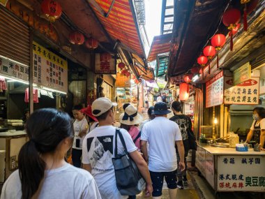 YENİ TAIPEI TAIWAN - 27 Ağustos 2024: Gezen ve alışveriş yapan turistlerle Jiufen eski caddesi. Geleneksel Çin fenerleri dar sokaklar boyunca asılı. Taipei yakınlarında popüler bir seyahat merkezidir..