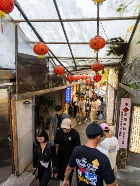 YENİ TAIPEI TAIWAN - 27 Ağustos 2024: Gezen ve alışveriş yapan turistlerle Jiufen eski caddesi. Geleneksel Çin fenerleri dar sokaklar boyunca asılı. Taipei yakınlarında popüler bir seyahat merkezidir..